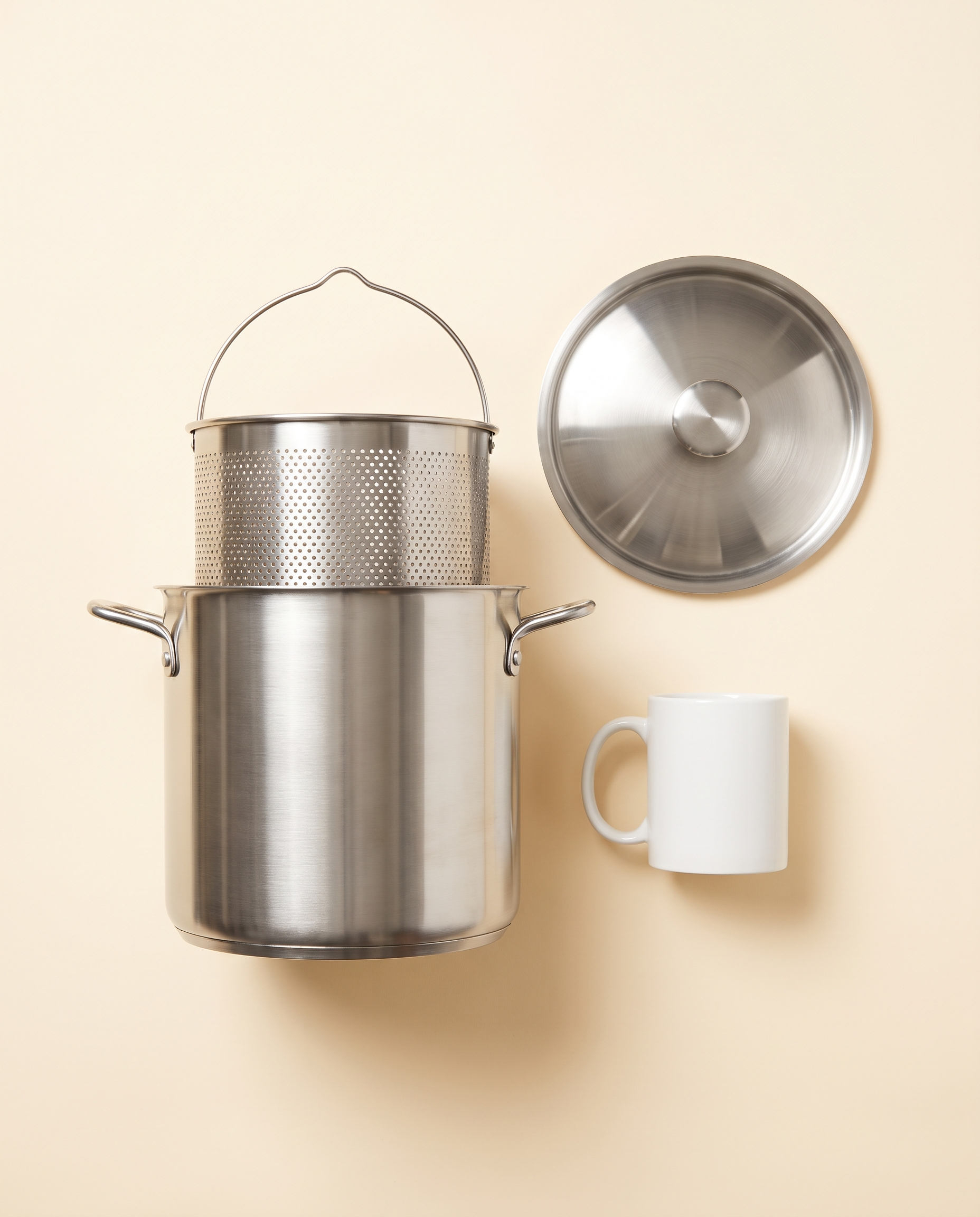 CrispNest Mini Fry Pot next to a coffee mug for size reference